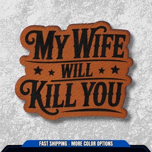 May include: A brown leather patch with the text "MY WIFE WILL KILL YOU" in black, stylized lettering. The patch has a decorative border and star accents. The background is a textured, light gray.