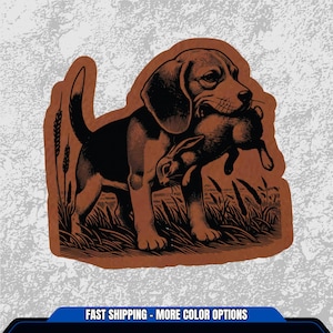 May include: A brown and black illustration of a Beagle dog carrying a rabbit in its mouth, set against a backdrop of tall grass. The image has a vintage, woodcut style, with the dog and rabbit in detailed profile.