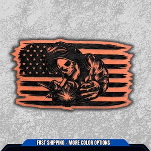 May include: An orange and black graphic featuring a skull-faced welder in front of an American flag design. The welder is depicted with a welding mask and tools, creating sparks. The flag has stars and stripes, with a distressed, weathered look.