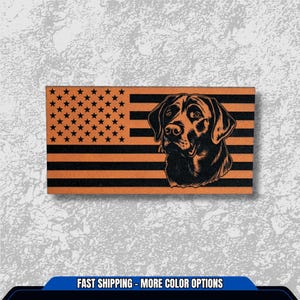 May include: A rectangular wooden plaque featuring an American flag design with a black and orange color scheme. The flag's stars are in the upper left corner, and a black Labrador Retriever's head is on the right. The text "FAST SHIPPING - MORE COLOR OPTIONS" is at the bottom.