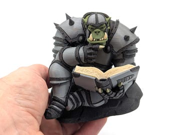 Figurina: Orco da battaglia che legge D&D