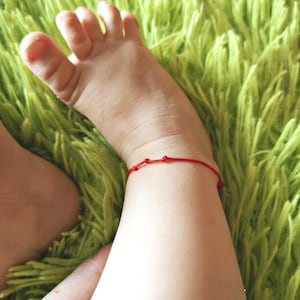 May include: A white ceramic mug with a black handle and the text "But First, Coffee" in a bold, black font. The mug is set against a blurred background, suggesting a cozy setting.