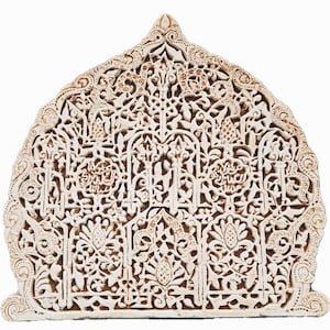 May include: A white, intricately carved stone archway with a detailed floral pattern. The archway is made of a light-colored stone and has a delicate, intricate design.