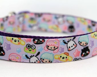 May include: A light purple pet collar featuring a repeating pattern of various cartoon character faces, including small figures with pink, blue, and yellow hair, a green frog, and a black bird, interspersed with small colorful stars.