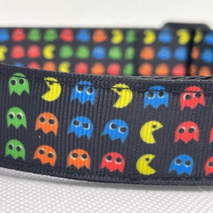 May include: Black dog collar with a repeating pattern of colorful Pac-Man ghosts and yellow Pac-Man characters.