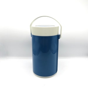 Op de afbeelding: Een blauwe en witte geïsoleerde drankenhouder met een handvat. De houder heeft een wit deksel met een geribbeld ontwerp.