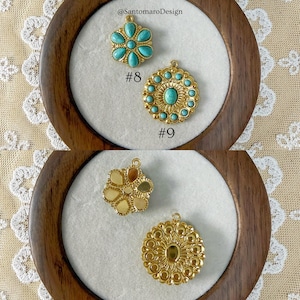 Peut inclure: Gros plan de pendentifs dor&eacute;s avec des accents turquoise et dor&eacute;s. Les pendentifs sont dans un cadre en bois avec le texte "@SantomaroDesign" et les num&eacute;ros #8 et #9. Les pendentifs ont un design floral et circulaire.