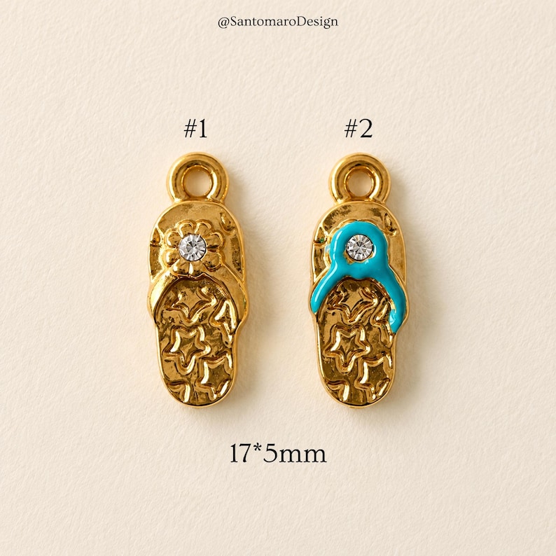 May include: Two gold-colored metal flip-flop charms. One features a flower with a clear crystal, the other has a turquoise strap and a clear crystal. The charms are 17mm x 5mm. The text "@SantomaroDesign" is at the top.