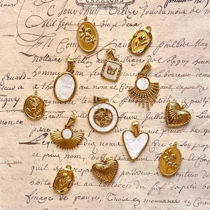 Peut inclure: Une collection de pendentifs dorés avec divers motifs, notamment des fleurs, des cœurs et des formes géométriques. Certains pendentifs présentent des incrustations de nacre blanche. Les pendentifs sont présentés sur un fond de papier de style vintage.