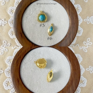 Peut inclure: Gros plan sur des pendentifs dor&eacute;s avec des accents de pierres turquoise. Deux pendentifs sont pr&eacute;sent&eacute;s dans un coffret &agrave; bijoux en bois. Un pendentif est rond et l'autre de forme ovale. Le texte "#5" et "#6" est visible.
