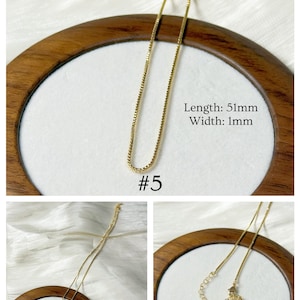 Op de afbeelding: Een delicate goudkleurige ketting met een box chain design. De ketting is 5,1 cm lang en 1 mm breed. De afbeelding bevat de tekst "#5" en de Instagram-handle van de verkoper. De ketting wordt gepresenteerd op een wit oppervlak.