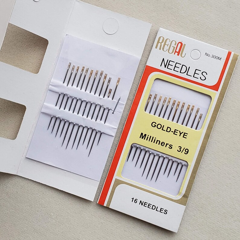 May include: A package of 16 gold-eye milliners needles, size 3/9, in a white and red cardboard box. The box says "Regal Needles No. 300M Gold-Eye Milliners 3/9 16 Needles".