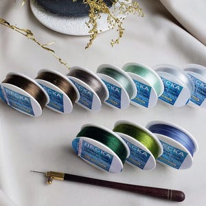 May include: Assortment of spools of clear fishing line in various colours, including brown, grey, green, and blue. Each spool is labelled with the brand name "ЛЕСКА" and the length of the line in metres.