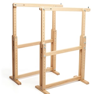 Può includere: Un supporto in legno regolabile per telai da ricamo. Il supporto è in legno naturale e ha un design semplice. Dispone di due livelli di altezza regolabili e una base robusta.