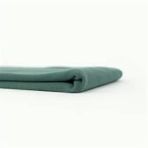 May include: A folded teal blue fabric swatch. The fabric has a soft, textured surface.