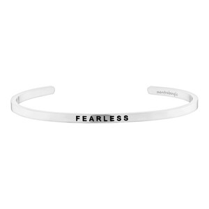 May include: Silver bangle bracelet with the word "FEARLESS" engraved on the front.