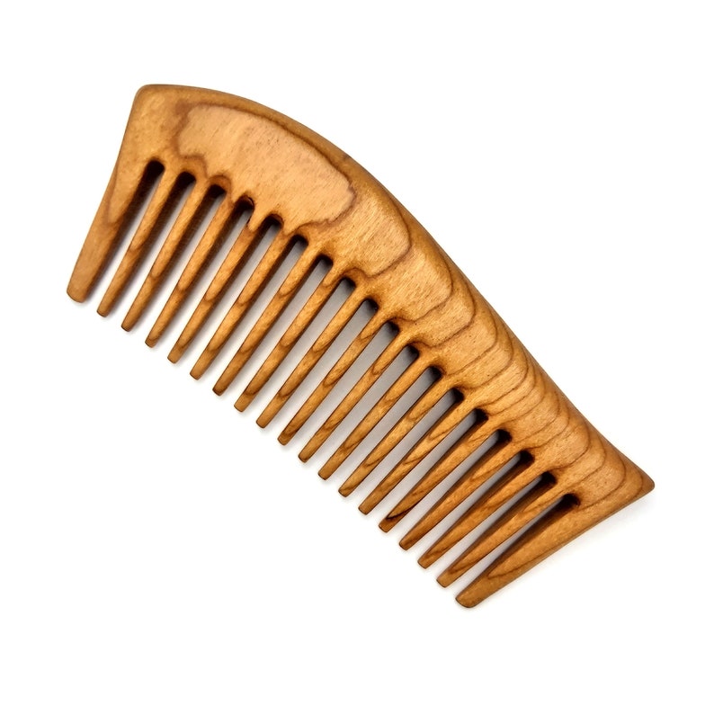 May include: A wooden comb with a natural brown finish and a curved shape. The comb has fine teeth and is designed for detangling and styling hair.
