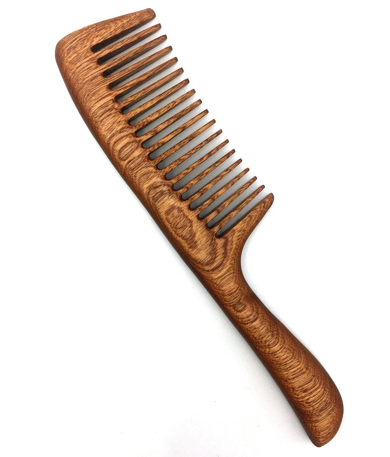 May include: A brown wooden comb with a curved handle. The comb has fine teeth and is made of natural wood.