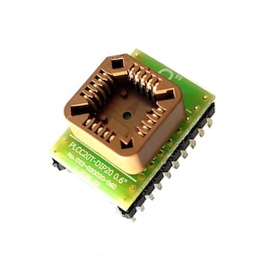 May include: A brown plastic PLCC20T-DIP20 0.6" socket on a green circuit board with gold-colored pins.