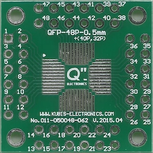Pode incluir: Uma placa de circuito impresso verde com um circuito integrado QFP-48P-0.5mm. A placa tem uma serigrafia branca com o texto "Q" e "ELECTRONICS" e o site "WWW.KUBIS-ELECTRONICS.COM". A placa também tem o texto "No. 011-050048-062 V. 2015.04".
