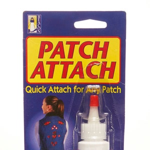 May include: A blue and yellow package with a bottle of Patch Attach fabric glue. The bottle is clear with a red cap and a white label that says "Patch Attach Quick Attach for Any Patch". The package also features a woman wearing a denim vest with colorful patches attached. The text on the package says "Permanent, Washable, Dry Cleanable, No Sewing, Fast & Easy, Non-Toxic".