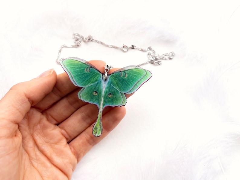 Close-up of the stunning green hues of the Green Lunar Moth Pendant - A calming and serene addition to your jewelry collection