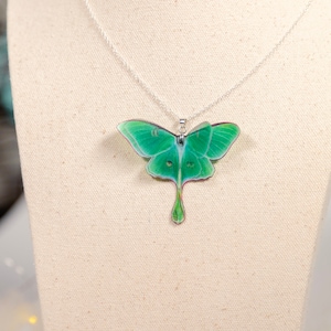 Green Lunar Moth Pendant on a mannequin bust - Add a boho touch to your outfit with this unique piece of jewelry