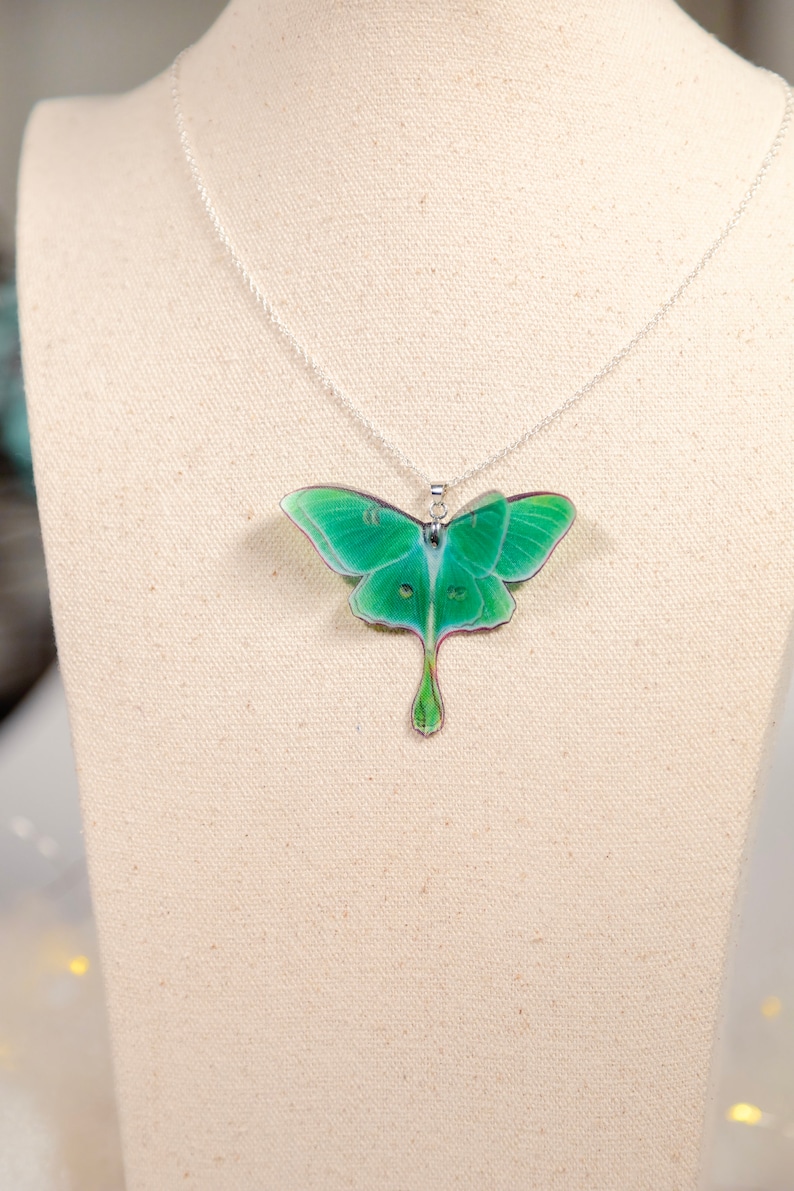 Green Lunar Moth Pendant on a mannequin bust - Add a boho touch to your outfit with this unique piece of jewelry