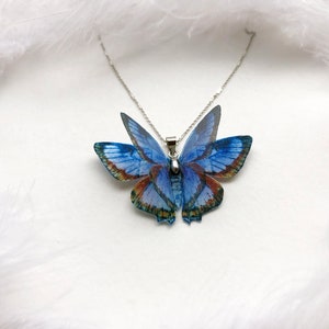 Blue butterfly pendant necklace on white background