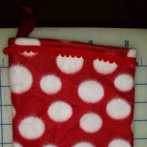 May include: Red stocking with white polka dots and a red ruffled trim at the top.