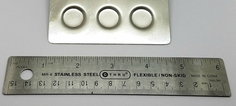 May include: A close-up of a silver ruler with black markings, measuring 6 inches. The ruler is labeled "MR-6 Stainless Steel Thru Flexible/Non-Skid Made in China".