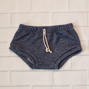 May include: Blue denim shorts with a white drawstring. The shorts have a relaxed fit and are made of a soft, comfortable fabric.