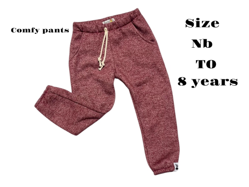 May include: Maroon comfy trousers with a drawstring waist and pockets. The text "Comfy pants" is on the left, and "Size Nb to 8 years" is on the right. These trousers are designed for children.