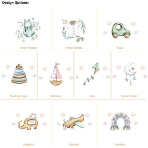 May include: Watercolor illustrations of baby-themed designs, including a green romper, white romper, truck, stacking rings, sailboat, kite, moon and stars, elephant, airplane, and rainbow. Text reads "Design Options:" and labels each design.