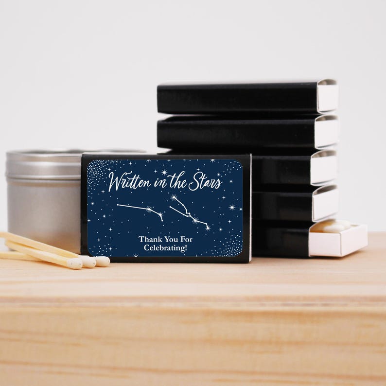 May include: A navy blue matchbox with a white constellation design and the text "Written in the Stars" and "Thank You For Celebrating!"