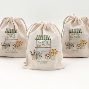 Three 5" x 7" drawstring bags with a watercolor "Fresh off the Market" design including a floral cart with flower pots filled with flowers and two lines of custom text.