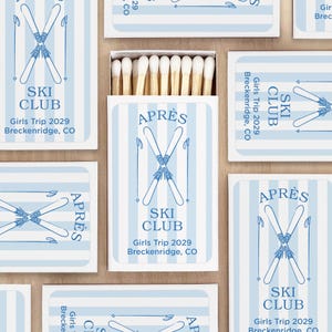May include: A collection of matchboxes with a light blue and white striped design. Each box features the words "SKI CLUB" and "APRÈS" with crossed skis. The text "Girls Trip 2029 Breckenridge, CO" is also visible.