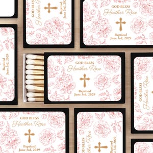 Puede incluir: Cajas de cerillas con un dise&ntilde;o floral y el texto "GOD BLESS Heather Rose" y "Baptized June 3rd, 2029". El dise&ntilde;o incluye una cruz e ilustraciones florales en una paleta de colores suaves. La caja de cerillas es negra.