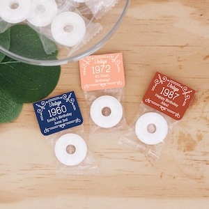 May include: Three small clear bags with white round mints and personalized labels. The labels are decorated with a vintage-style border and text that reads "Vintage 1960 Emily's Birthday June 3rd", "Vintage 1972 It's Tina's Birthday!" and "Vintage 1987 Happy Birthday Alex!"