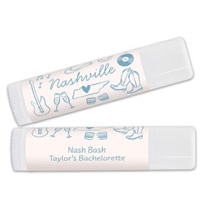 Pu&ograve; includere: Due tubetti di balsamo per labbra bianchi con etichette blu e bianche. Il tubetto superiore presenta un disegno di una chitarra, bicchieri di champagne, un cuore, lo stato del Tennessee, un cappello da cowboy e un disco. Il testo sull'etichetta recita "Nashville". Il tubetto inferiore presenta un disegno di bicchieri di champagne, una chitarra e stivali da cowboy. Il testo sull'etichetta recita "Nash Bash Taylor's Bachelorette".