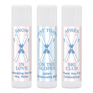 May include: Three lip balm tubes with white caps and striped pink and blue backgrounds. Each tube features a pair of crossed skis and text: "SNOW IN LOVE", "LAST TOAST ON THE SLOPES", and "APRES SKI CLUB".