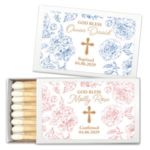 Puede incluir: Dos cajas de cerillas blancas con dise&ntilde;os florales y texto dorado. Una caja tiene detalles florales azules y dice "GOD BLESS Owen David Baptized 04.06.2029." La otra tiene detalles florales rosas y dice "GOD BLESS Molly Rose Confirmed 04.06.2029."