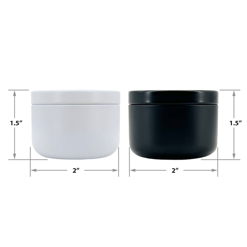 May include: Two small, round metal containers, one white and one black, with lids. Each container is 2 inches in diameter and 1.5 inches tall. The containers are shown against a white background.
