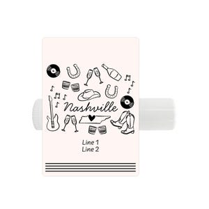 Pu&ograve; includere: Un tubetto di balsamo per labbra bianco con un design in bianco e nero che presenta una chitarra, un cappello da cowboy, un ferro di cavallo, flute di champagne, un disco e il testo "Nashville" con un cuore e lo stato del Tennessee. &Egrave; incluso anche il testo "Line 1 Line 2".