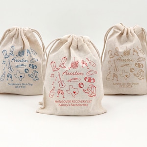 5" x 7" cotton drawstring bags printed with hand drawn Austin icons including cowboy boots, disco ball, boat, and a guitar along with two lines of personalized text.