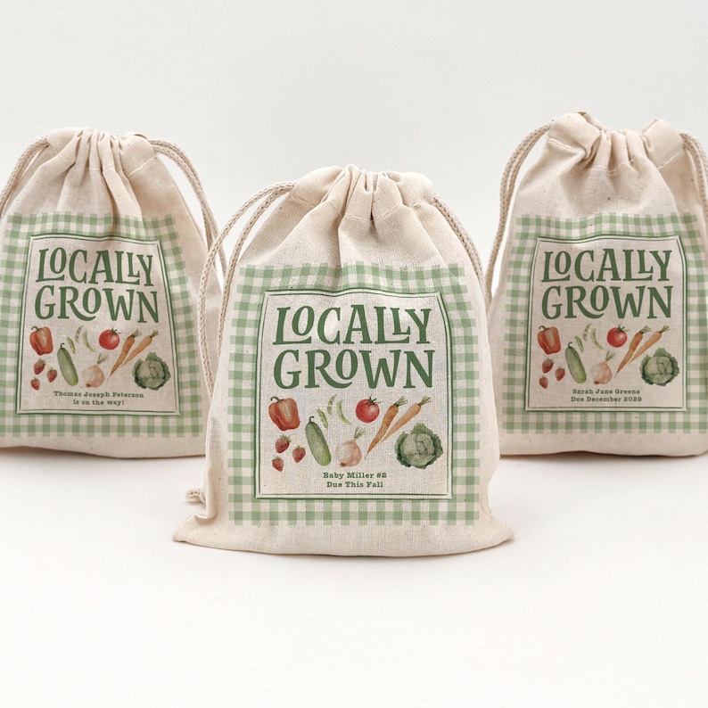 Three beige drawstring bags (5" x 7") with text and graphics. The bags say Locally Grown, have water colored veggies and fruit, and also have a green and cream checkered border.  Text includes names and baby shower dates.
