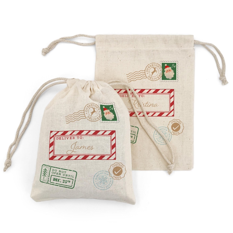 May include: Two beige drawstring gift bags with holiday-themed postage stamp designs. One bag reads "Deliver to: James" in a red frame. The other bag reads "Deliver to: Kristina". Both bags have a "Do Not Open Until Dec. 25th" stamp.