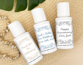 May include: Three small white bottles of sunscreen with colorful labels. The labels feature a floral design with lemons and the text "Thank You For Celebrating!" on one bottle, "Jack + Kelly Our Wedding! June 14th, 2028" on another, and "Happy Anniversary! Love, Jack" on the third.