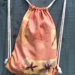 Orangefarbener Blumen-Rucksack mit Kordelzug: Leichte Umhängetasche aus Canvas.