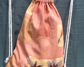 Orangefarbener Blumen-Rucksack mit Kordelzug: Leichte Umhängetasche aus Canvas.